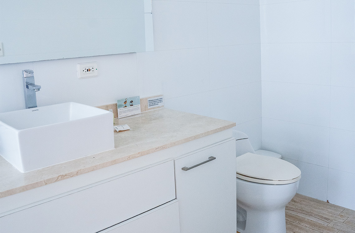 Baño moderno con lavabo sobre encimera, inodoro y tocador, ideal para tu Marina Puerto Velero.