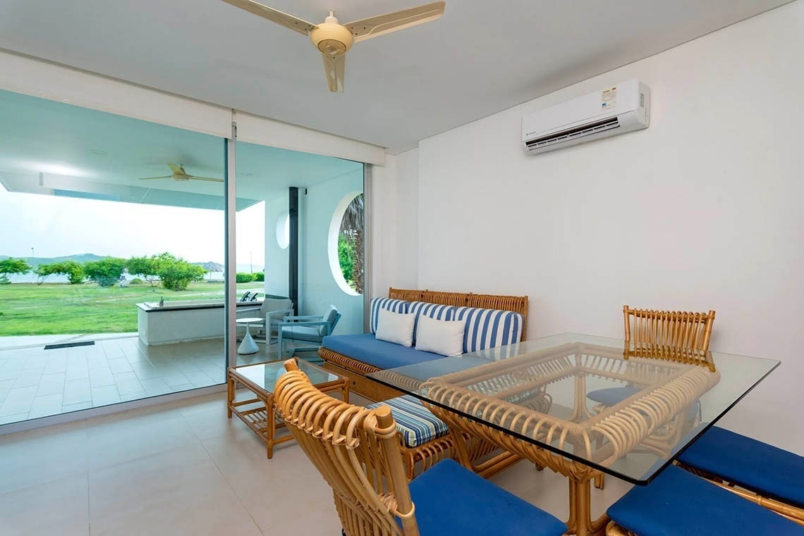 Living room overlooking Marina Puerto Velero, with rattan furniture and AC.