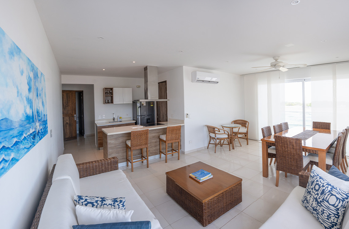 Amplia sala de estar y cocina de hotel con arte náutico, ideal para Marina Puerto Velero.