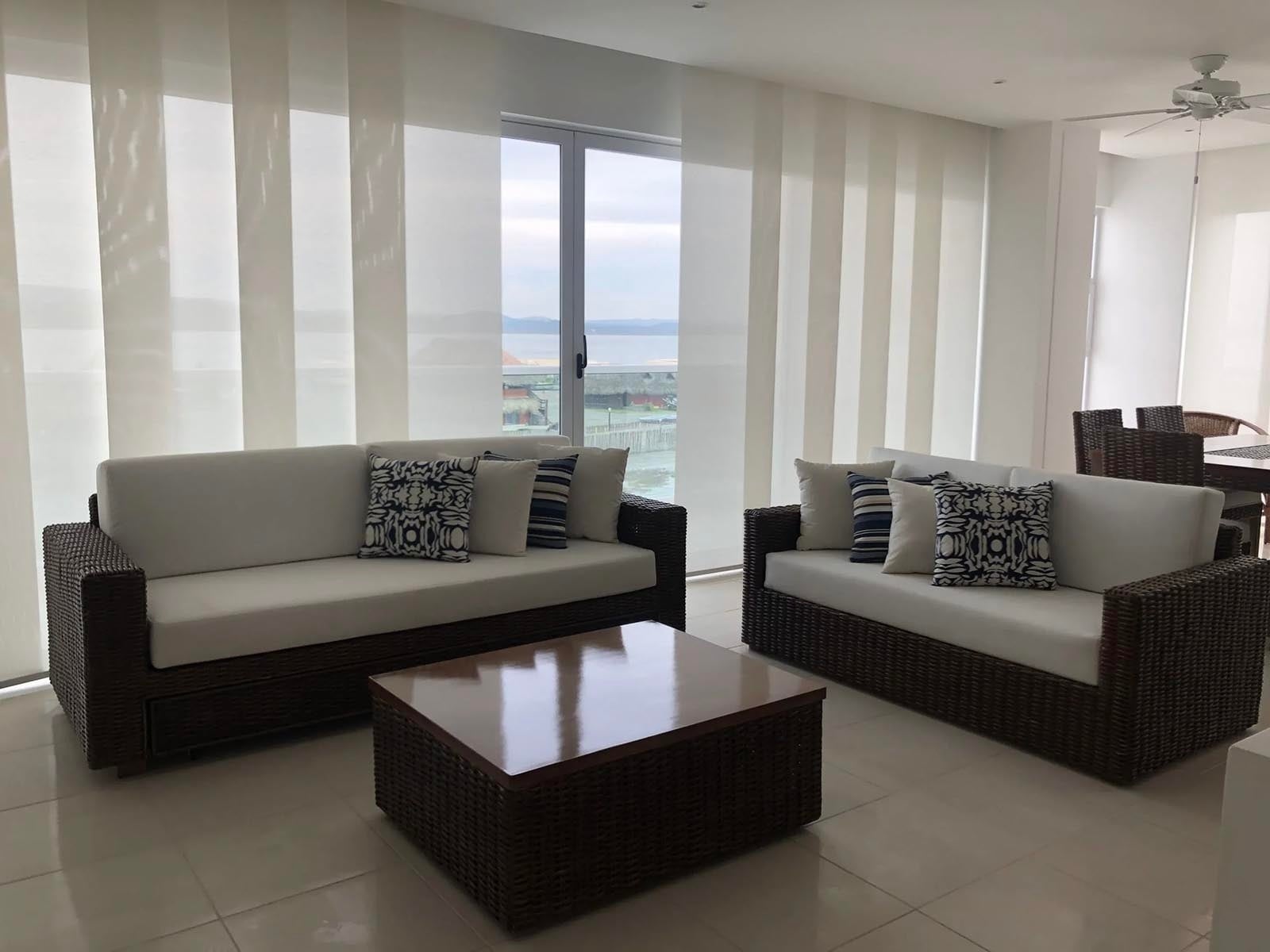 Sofá y mesa de centro en sala con vista a la Marina Puerto Velero.