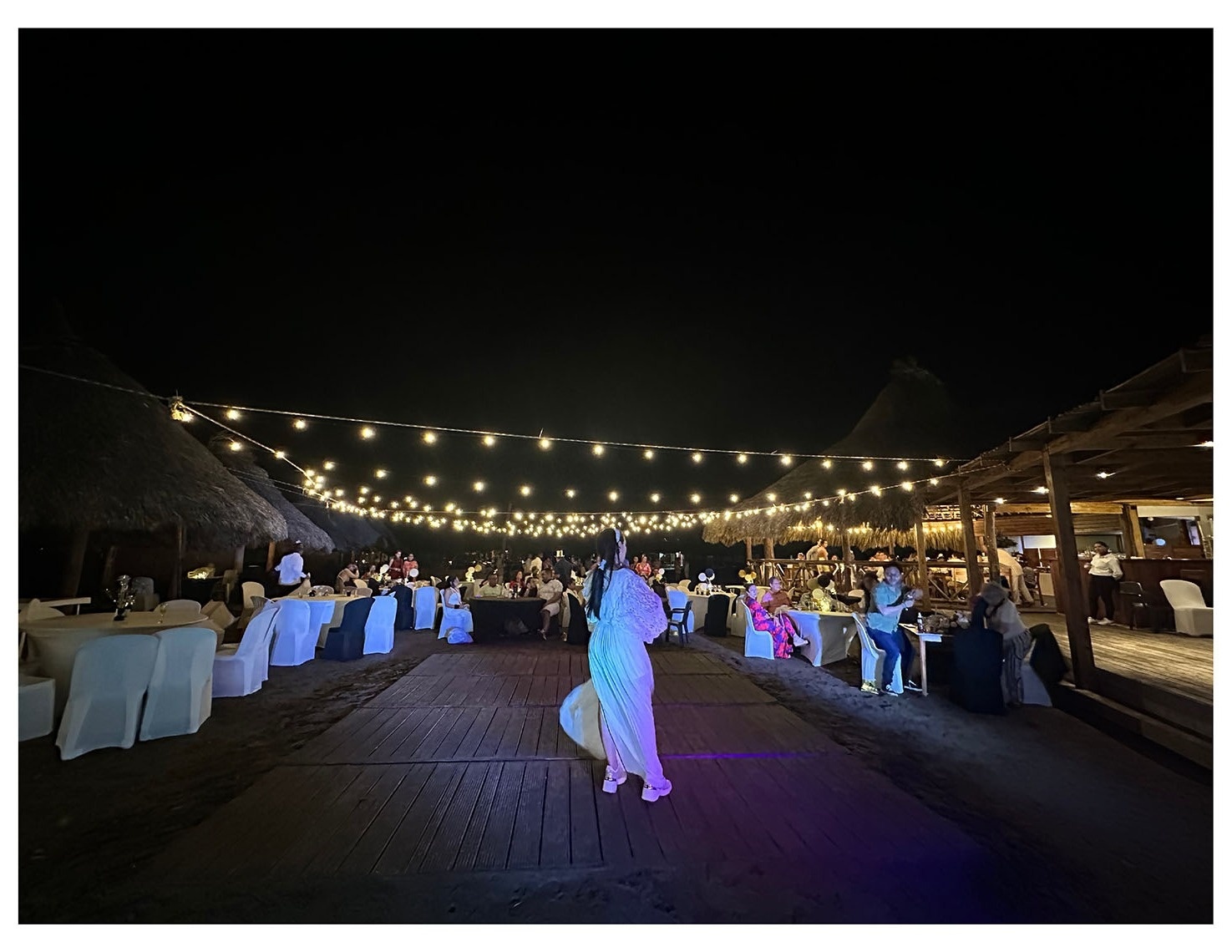 Evento nocturno en Marina Puerto Velero con luces y mesas decoradas.