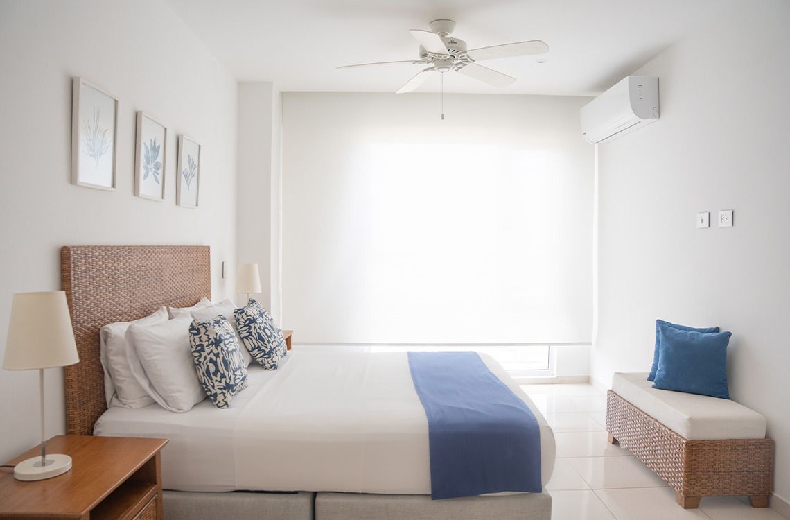 Suite con cama king, decoración costera, y aire acondicionado. Marina Puerto Velero