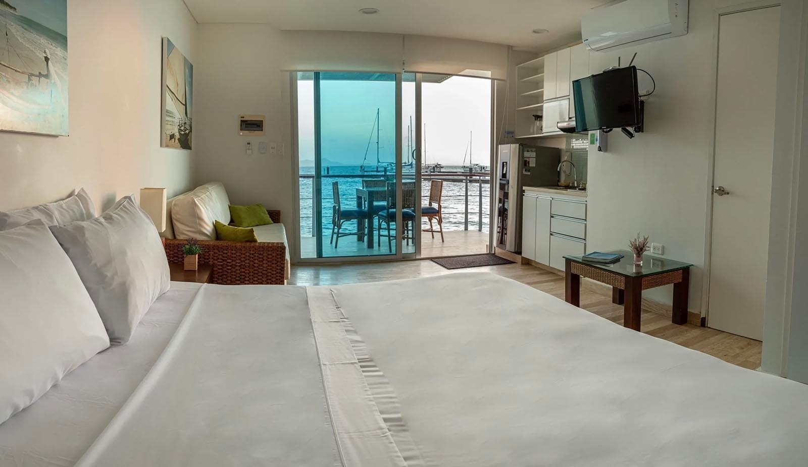 Estudio moderno en Marina Puerto Velero con cama king, sofá, cocina y balcón al mar.