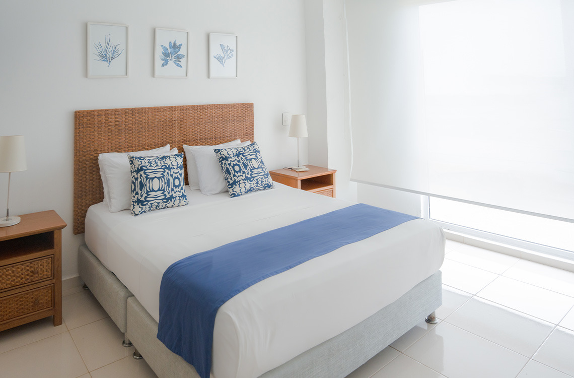 Marina Puerto Velero: Cama cómoda con decoración costera y luz natural.