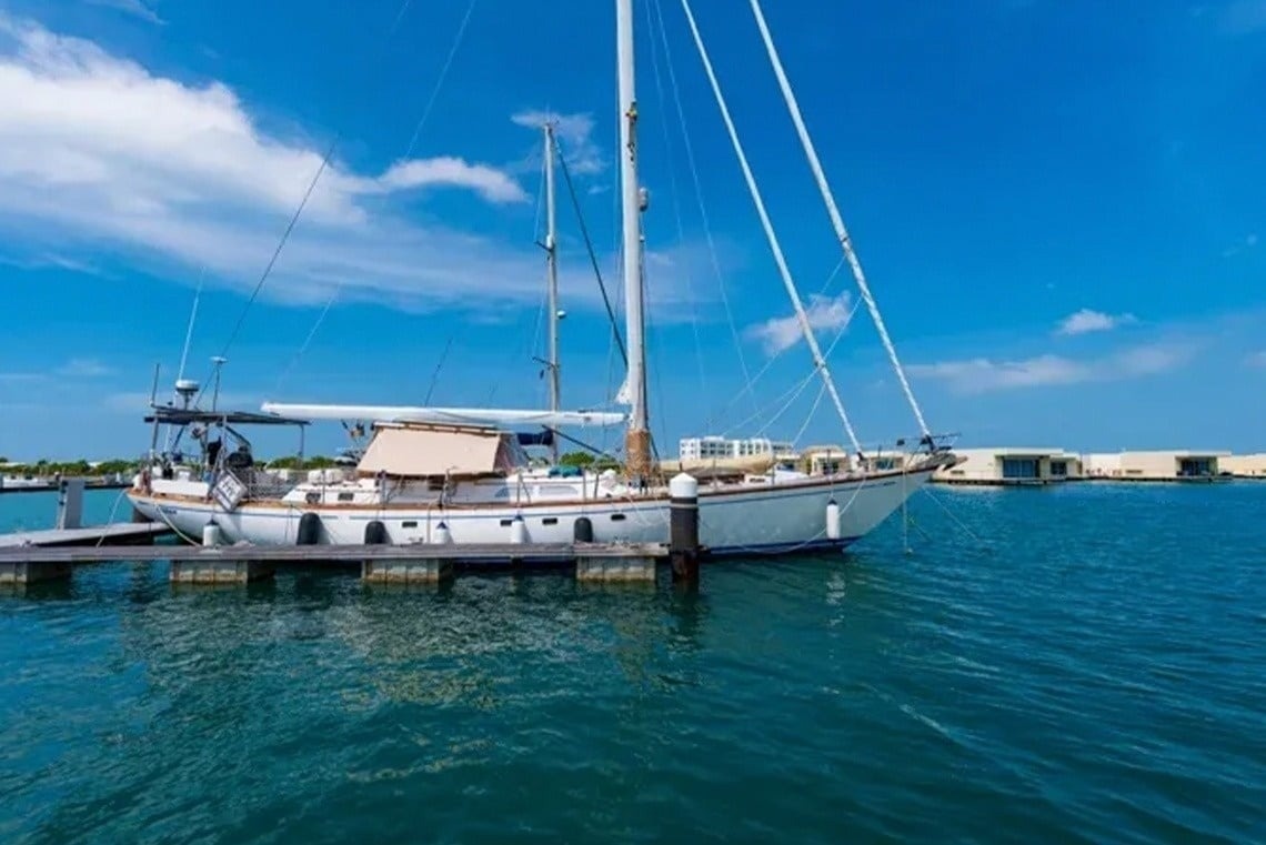 Sailboat docked at Marina Puerto Velero, featuring blue waters and clear skies.