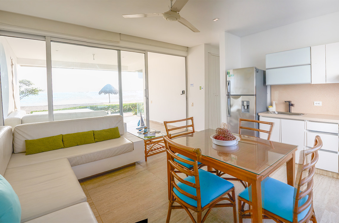 Sofá blanco con vista al mar y mesa de comedor, ideal para Marina Puerto Velero.
