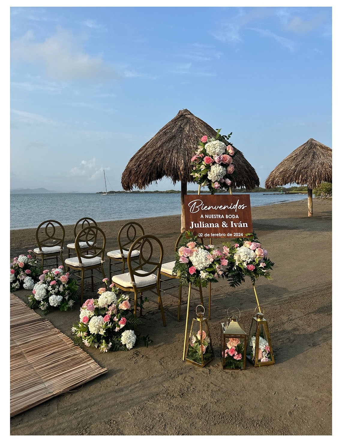 Ceremonia de bodas frente al mar en Marina Puerto Velero, adornada con flores y sillas doradas.