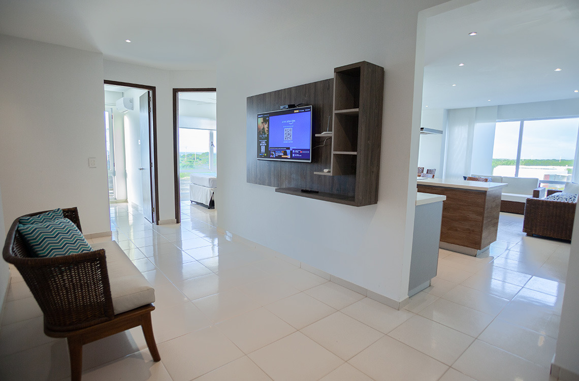 Sala de estar luminosa de hotel con TV y asientos cómodos. Marina Puerto Velero, vista exterior.