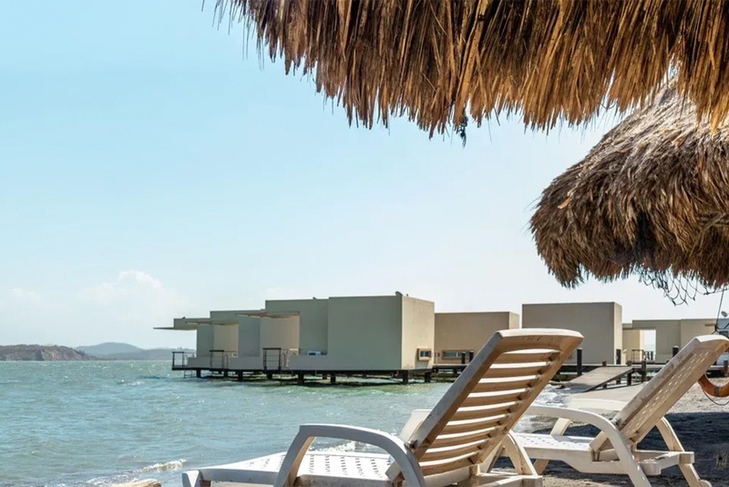 Beachfront loungers at Marina Puerto Velero with overwater bungalows.