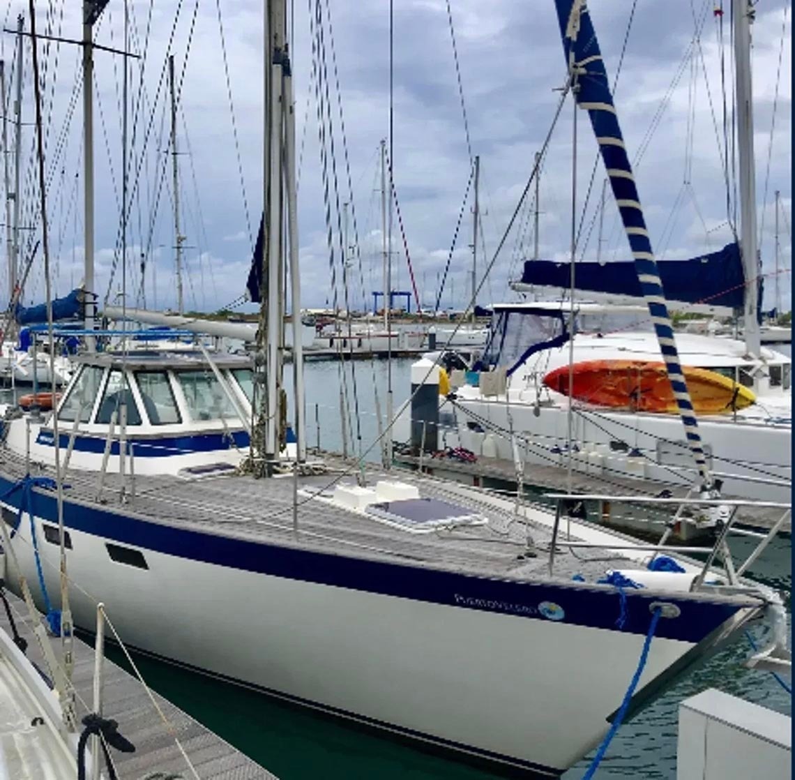 White and blue sailboat docked at Marina Puerto Velero.