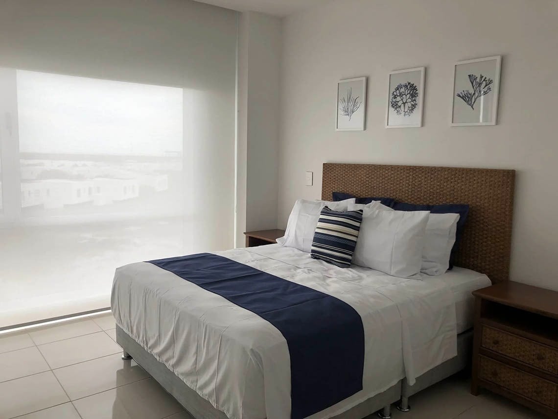 Marina Puerto Velero room with ocean view, comfortable bed, and marine art.