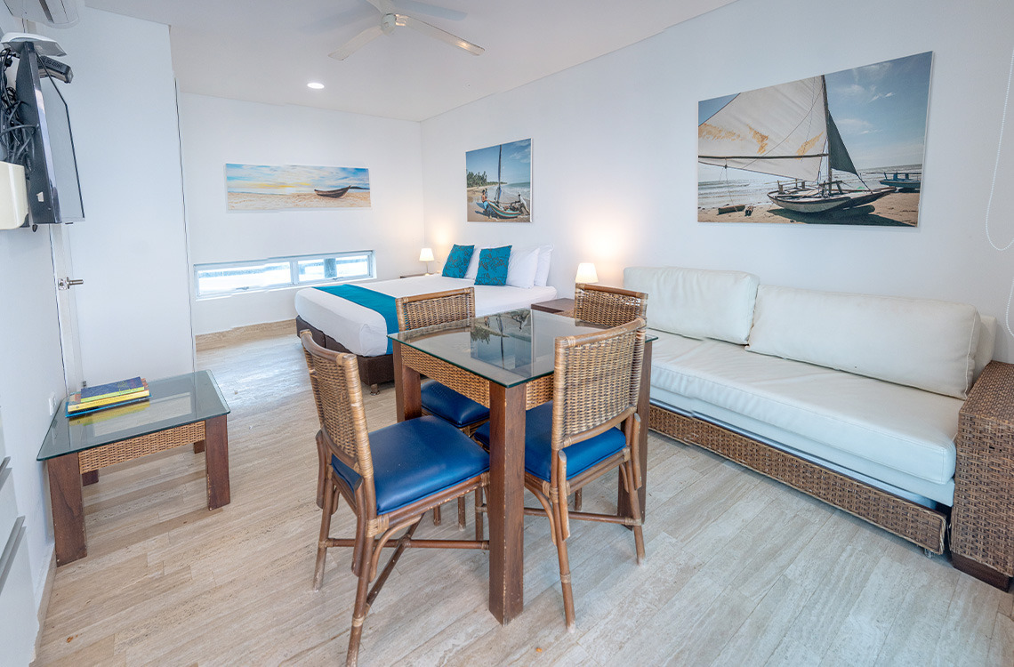 Amplia habitación con cama doble, sala de estar y mesa de Marina Puerto Velero.