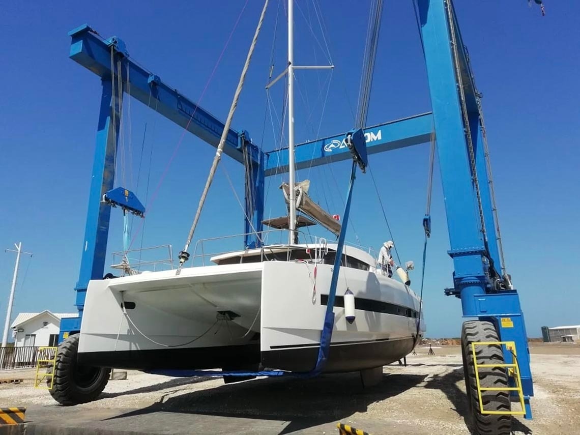 Catamaran lifted by crane at Marina Puerto Velero, ready for maintenance.