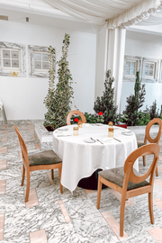 a round table with a white table cloth and chairs