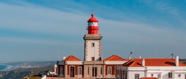 Farol vermelho e branco em hotel Marmoris: Corporative com telhados laranja e vista para o mar