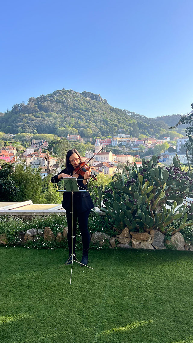 Mulher tocando violino em um jardim com vista para o palácio da Pena, Sintra. Marmoris: Corporative