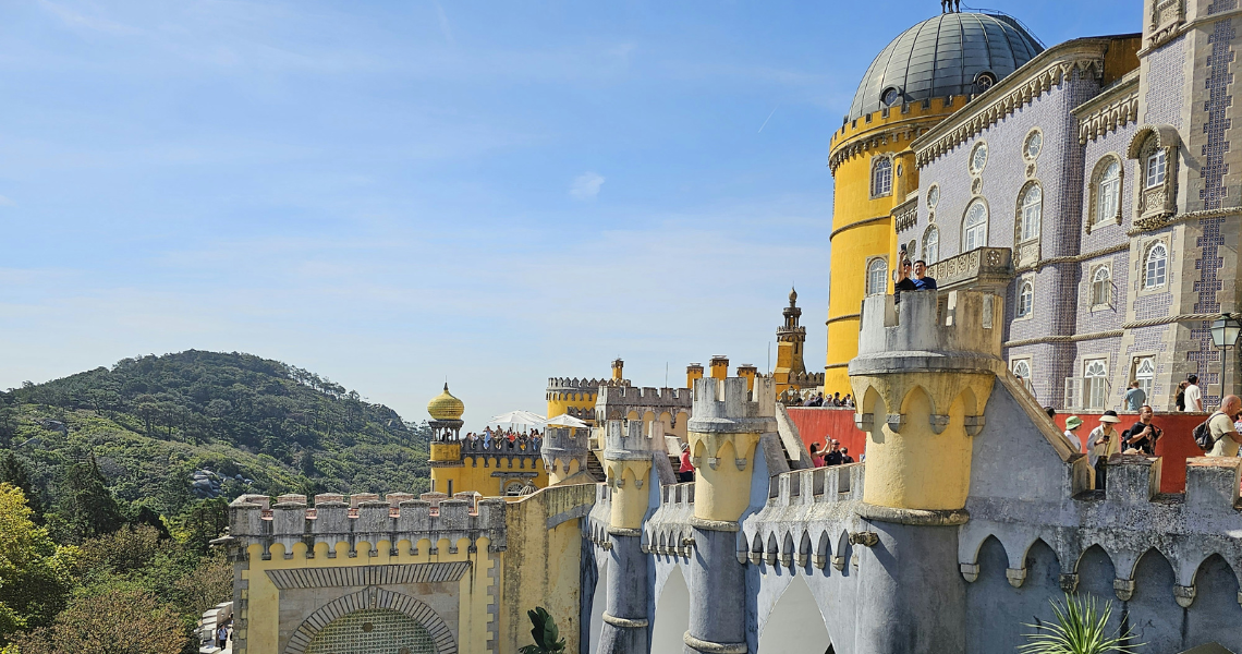 um grupo de pessoas está ao lado de um grande castelo