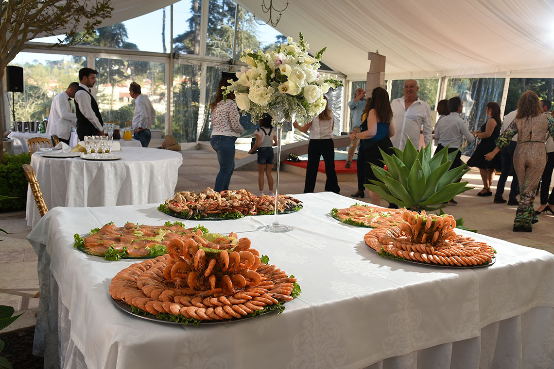 Buffet de frutos do marMarmoris: Corporative em evento especial, com pessoas dançando ao fundo.