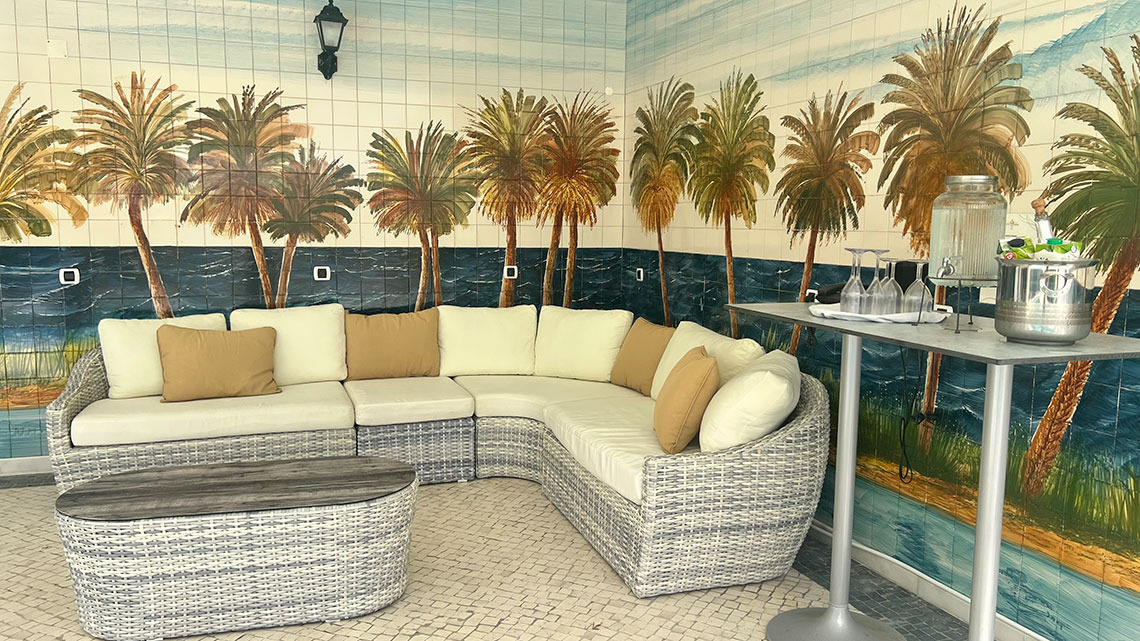 Salão com sofá em L e mesa de bar, decoração tropical de hotel Marmoris: Corporative.