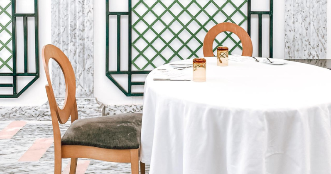 una mesa redonda con una sábana blanca y dos vasos encima