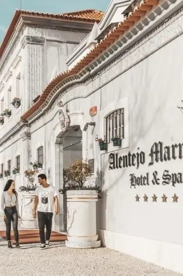 um homem e uma mulher estão andando na frente de um prédio branco .
