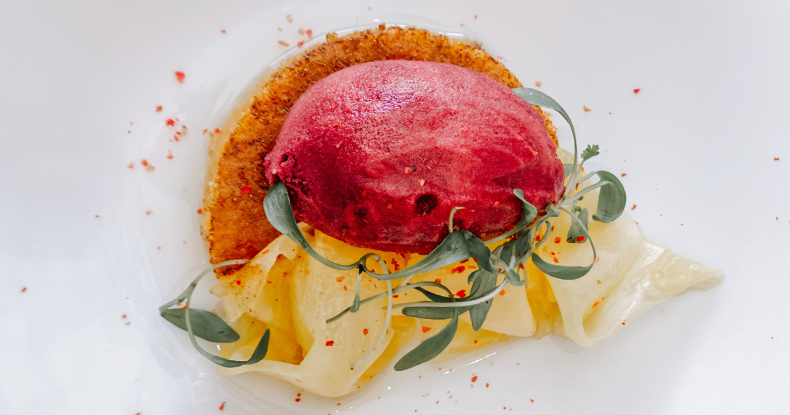 um prato branco com macarrão e sorvete vermelho