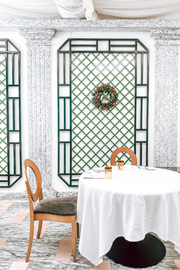 a christmas wreath hangs above a table in a restaurant