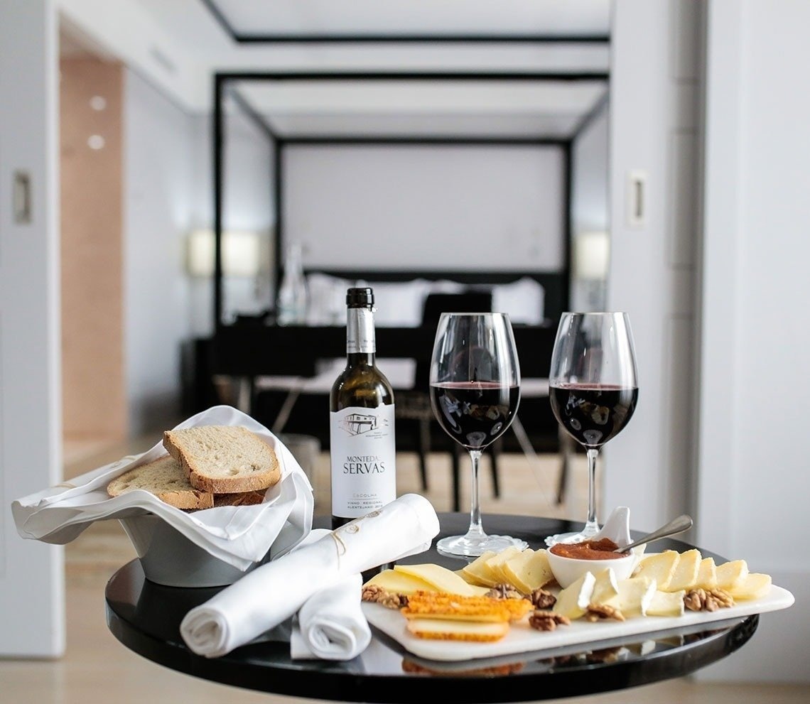 a man and woman are sitting on a dock near a lake