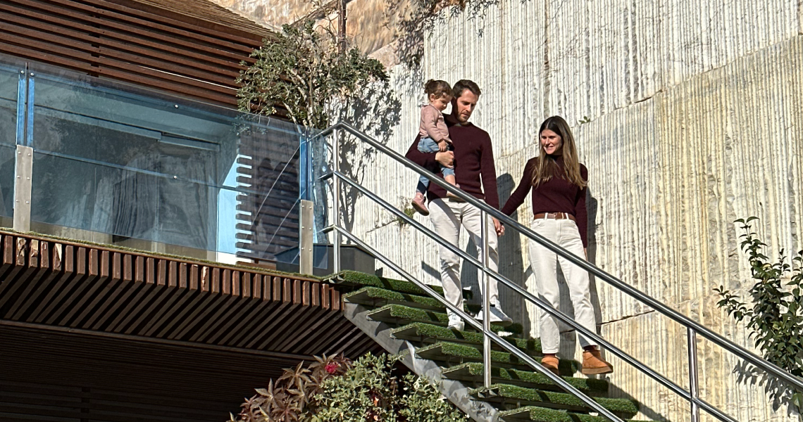 um homem e uma mulher estão segurando um menino nas escadas