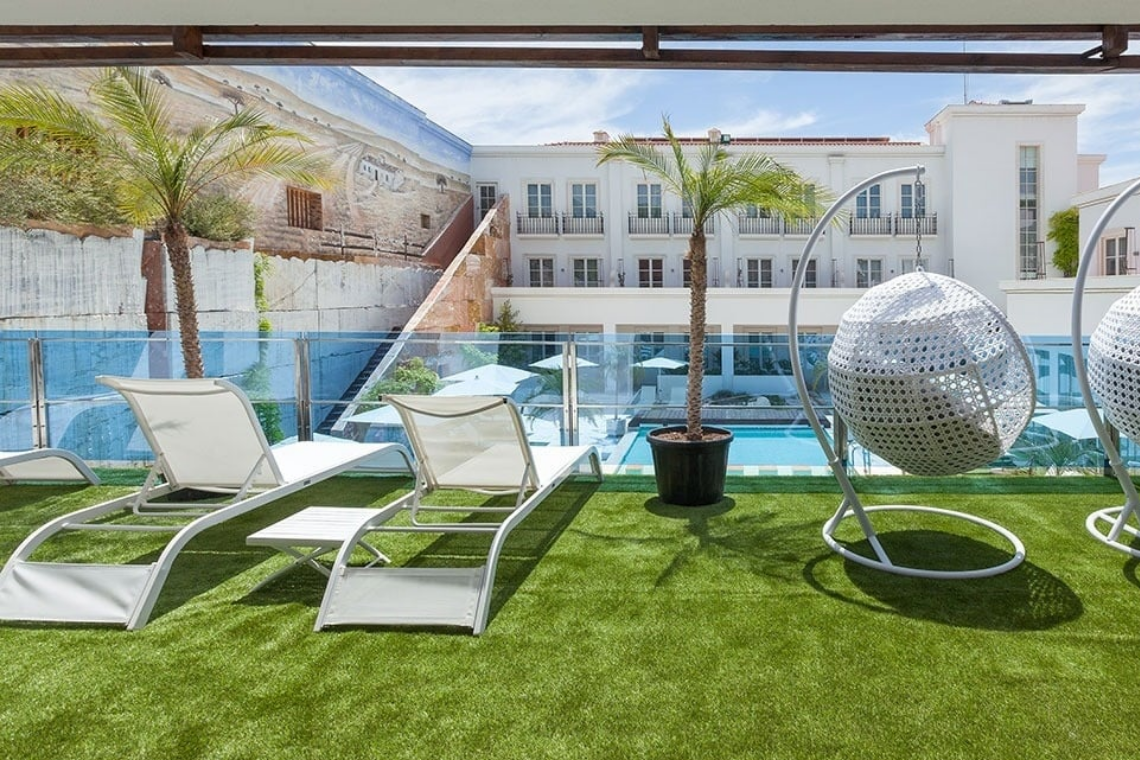 Alentejo Marmòris Hotel: Piscina e áreas de lazer com espreguiçadeiras e cadeiras suspensas.