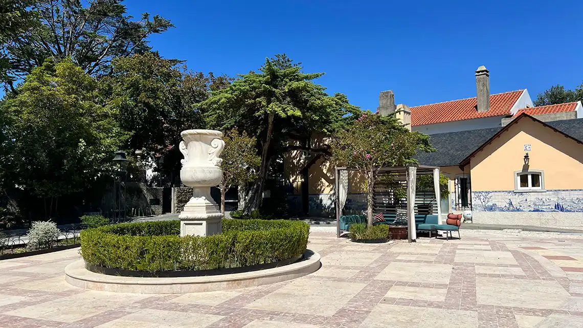 Marmoris Hotels courtyard with urn fountain, seating area, and traditional Portuguese tiles.