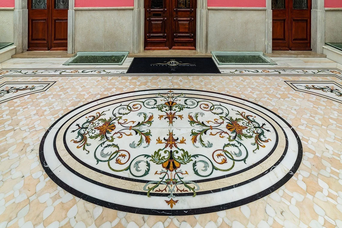 Elegant marble floor inlay with ornate floral design at Marmoris Hotels entrance.
