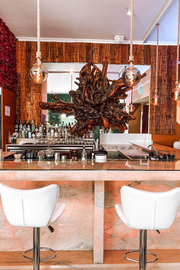 a bar with a large wooden sculpture hanging from the ceiling