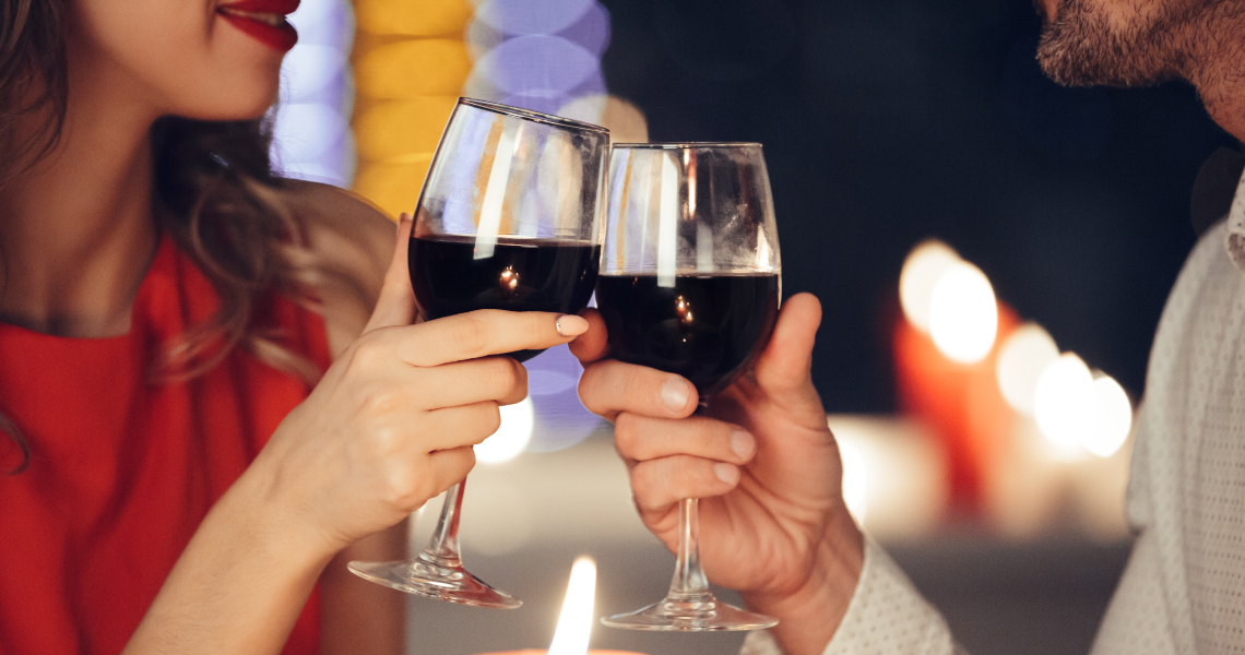 um homem e uma mulher brindando com taças de vinho