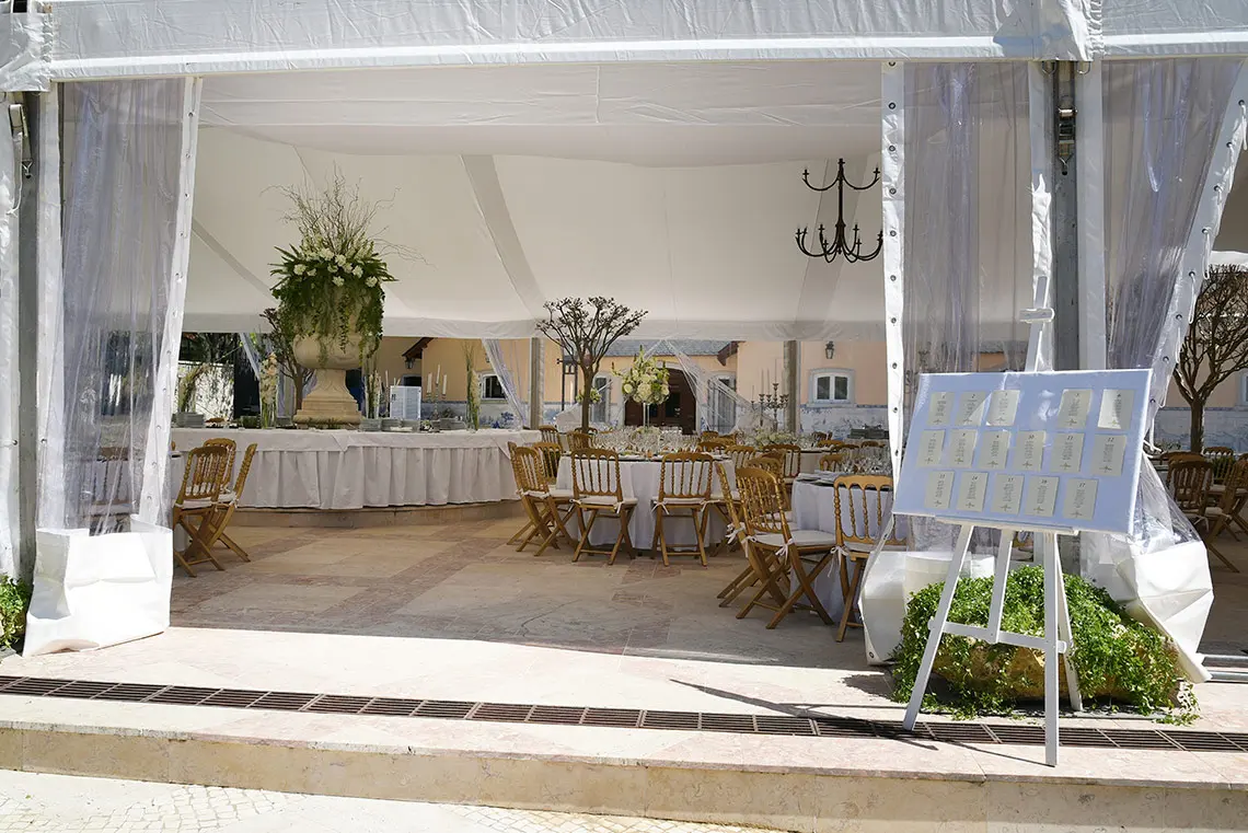 Elegant Marmoris Hotels tent with tables, chairs, and a seating chart for an outdoor event.