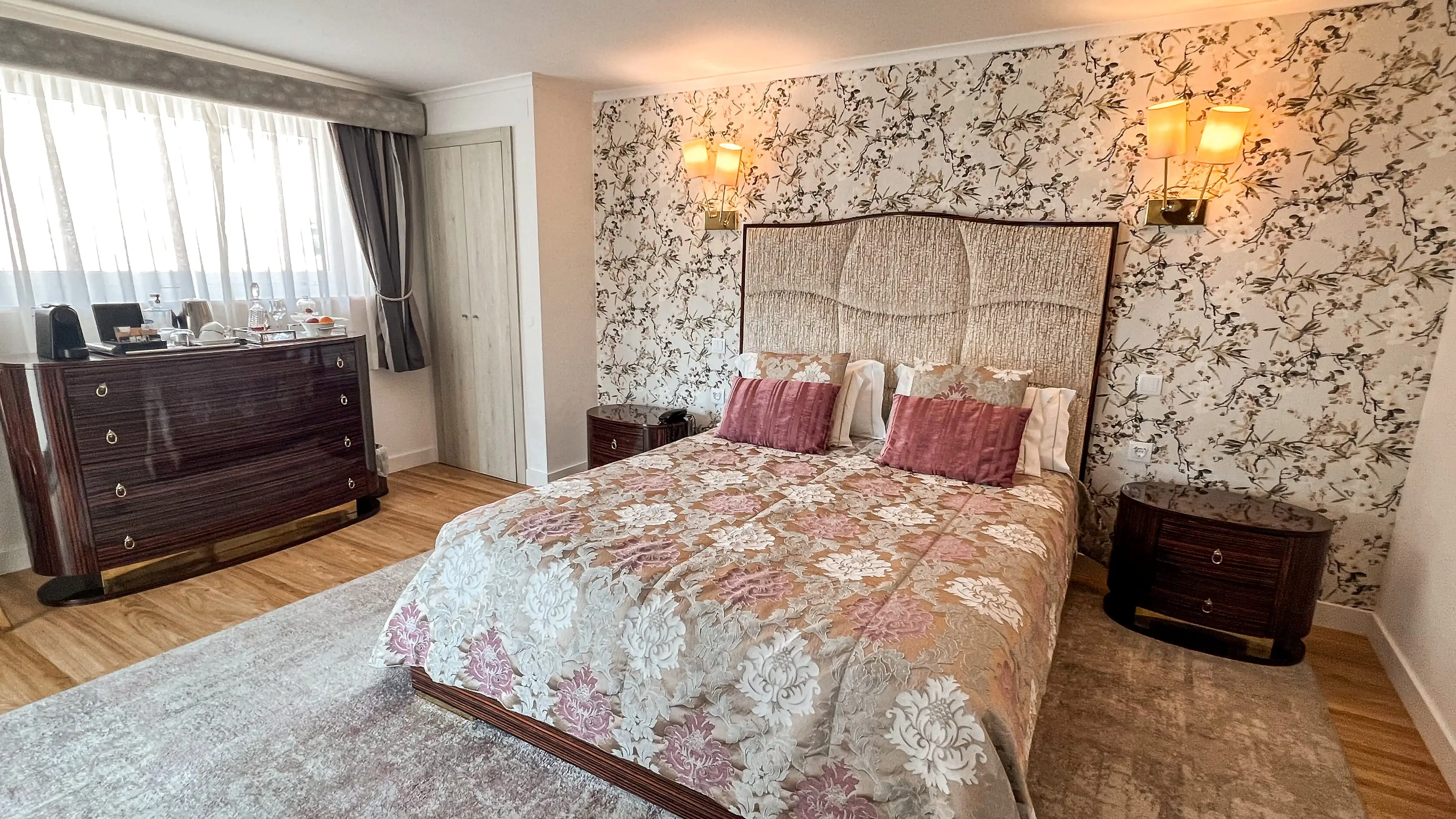 Marmoris Hotels: quarto elegante com papel de parede floral, cama de luxo e móveis clássicos.