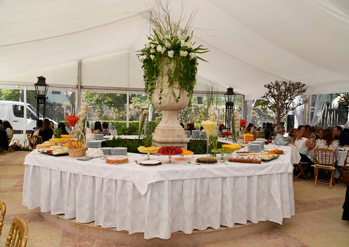 Elegant outdoor buffet Marmoris Hotels setup with catered desserts and fruits under a white tent.