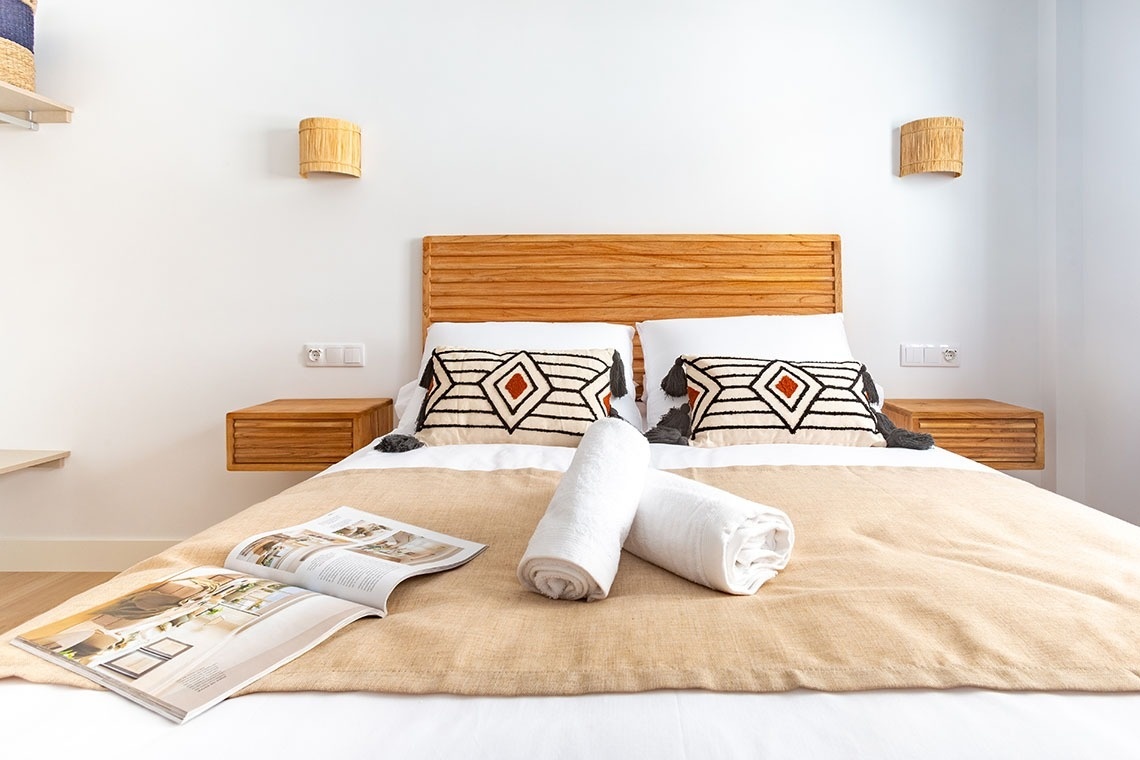 una cama con dos almohadas y una revista sobre la cama