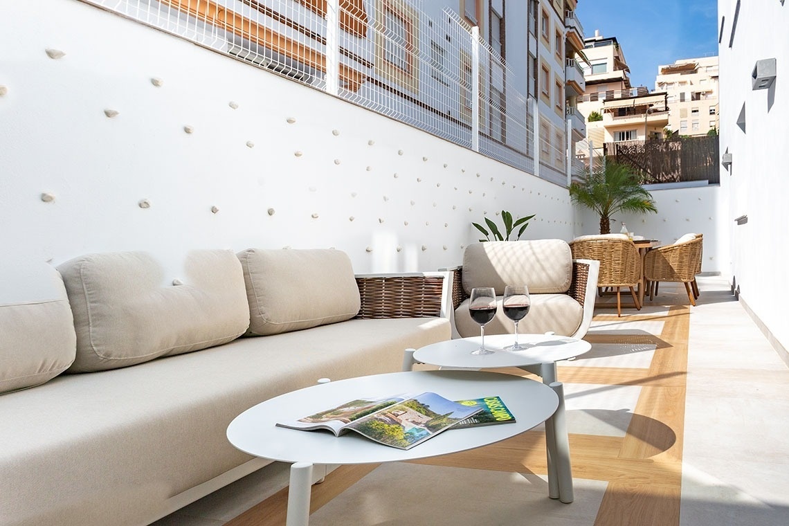 una mesa blanca con una revista y dos copas de vino sobre ella