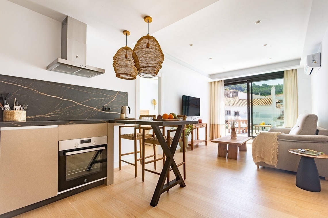 una cocina con electrodomésticos y una mesa con frutas encima