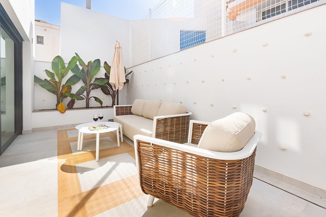 un patio con un sofá y una silla de mimbre