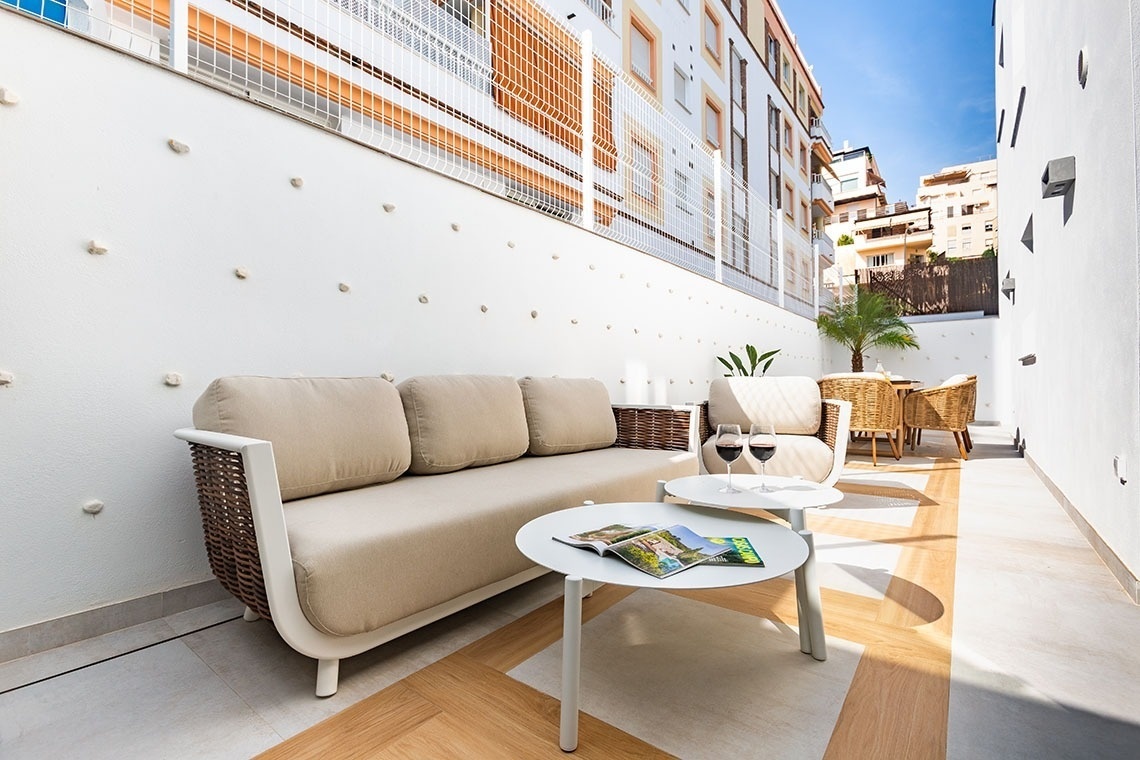 un sofá y una mesa con copas de vino en un patio