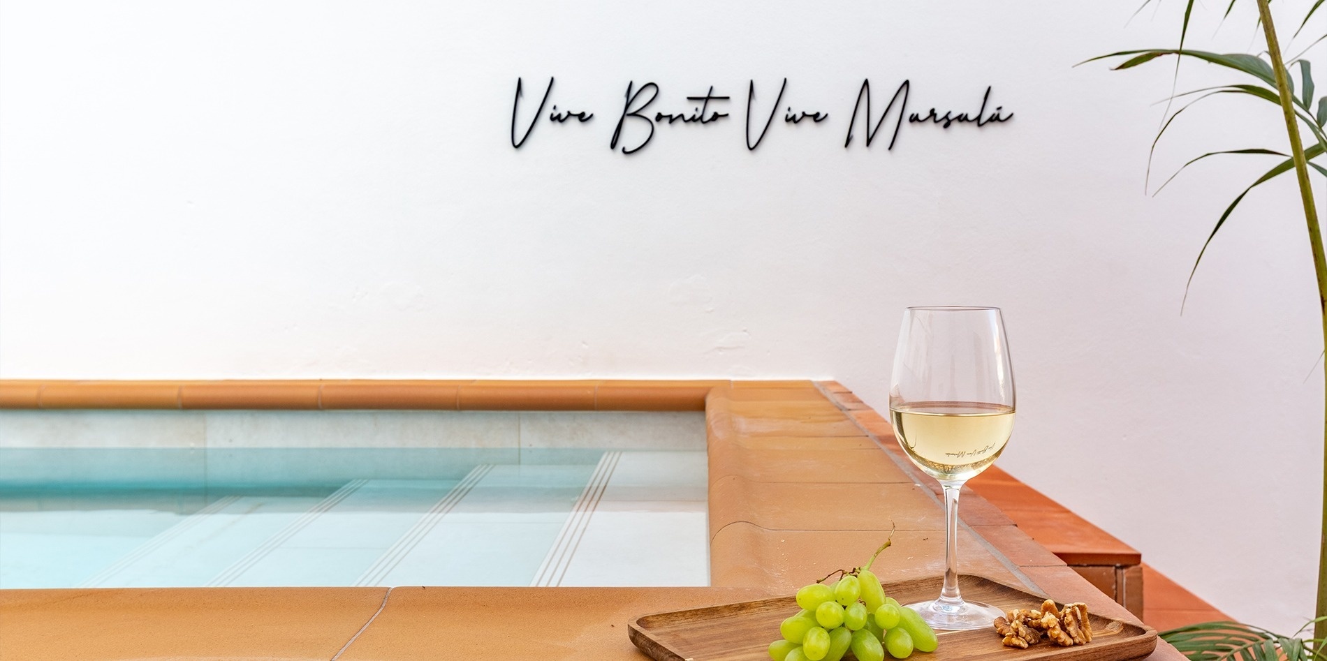 una mujer con gafas de sol amarillas se apoya en una pared de madera