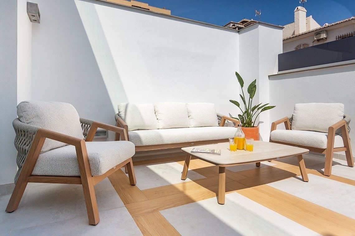 un sofá y dos sillas junto a una mesa