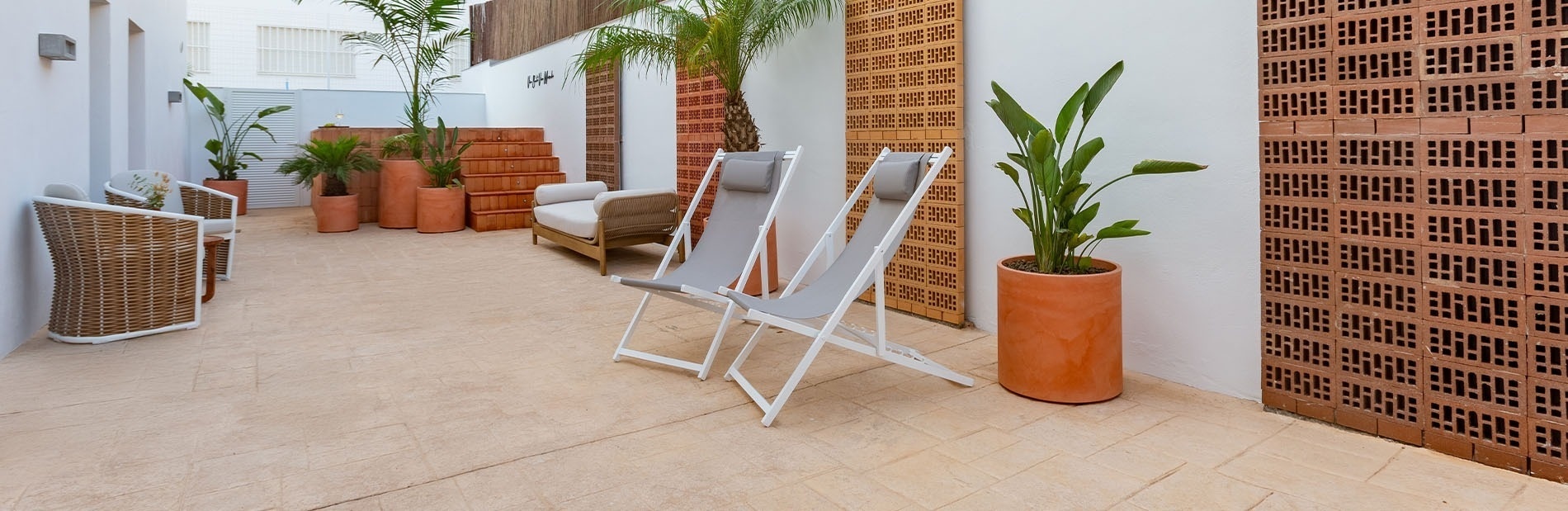 dos sillas blancas están sentadas en un patio