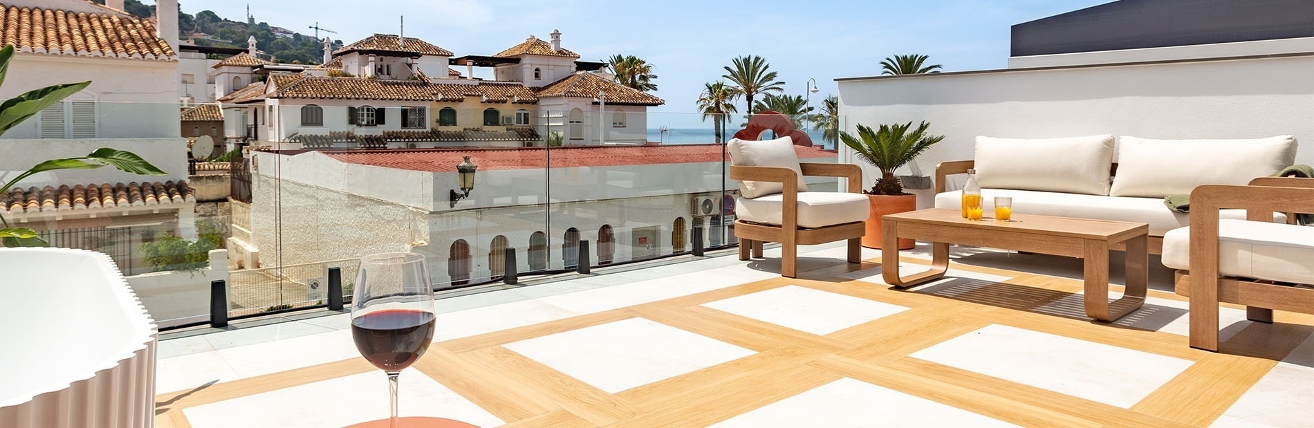 una terraza con muebles y una copa de vino