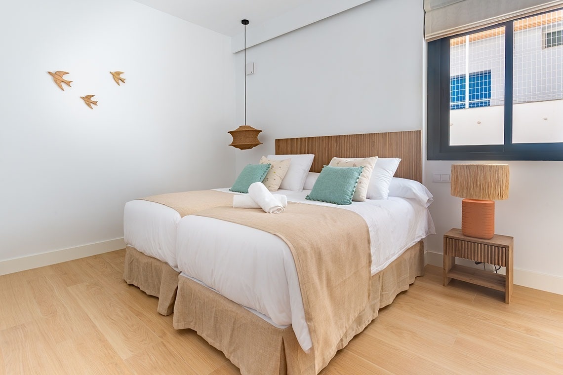 un dormitorio con dos camas y una lámpara