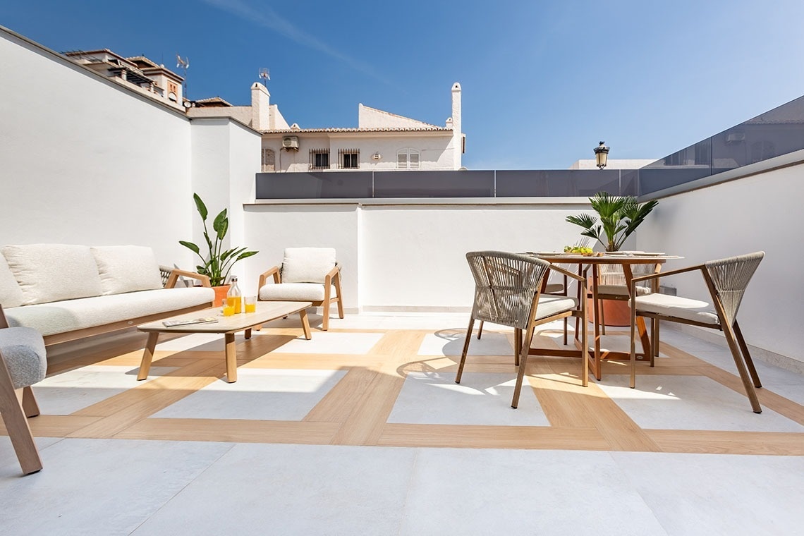una terraza con una mesa y sillas y un sofá