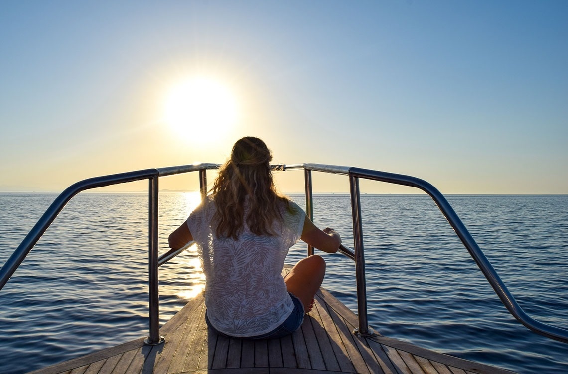 una mujer con una mochila azul se para en la cima de una montaña