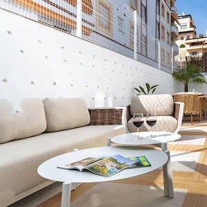 una mesa blanca con una revista y dos copas de vino sobre ella